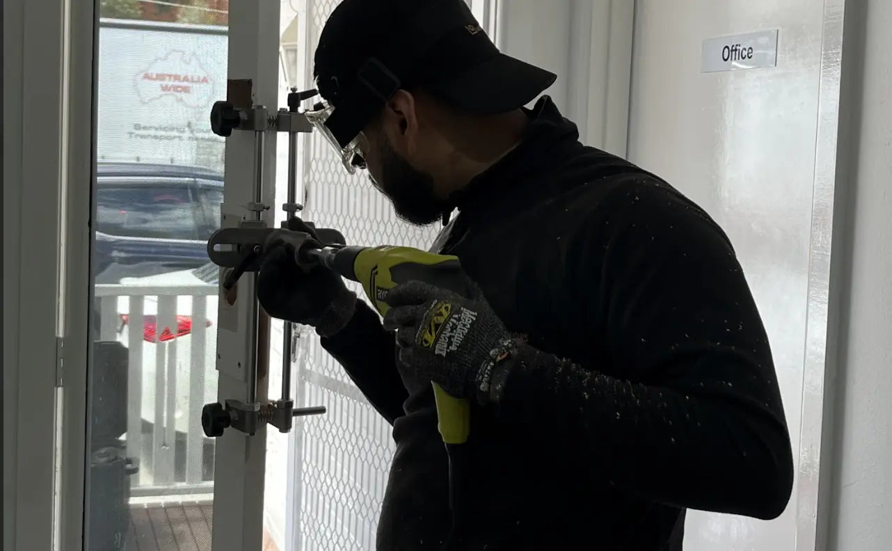 Installer carefully preparing a door for a smart-lock installation