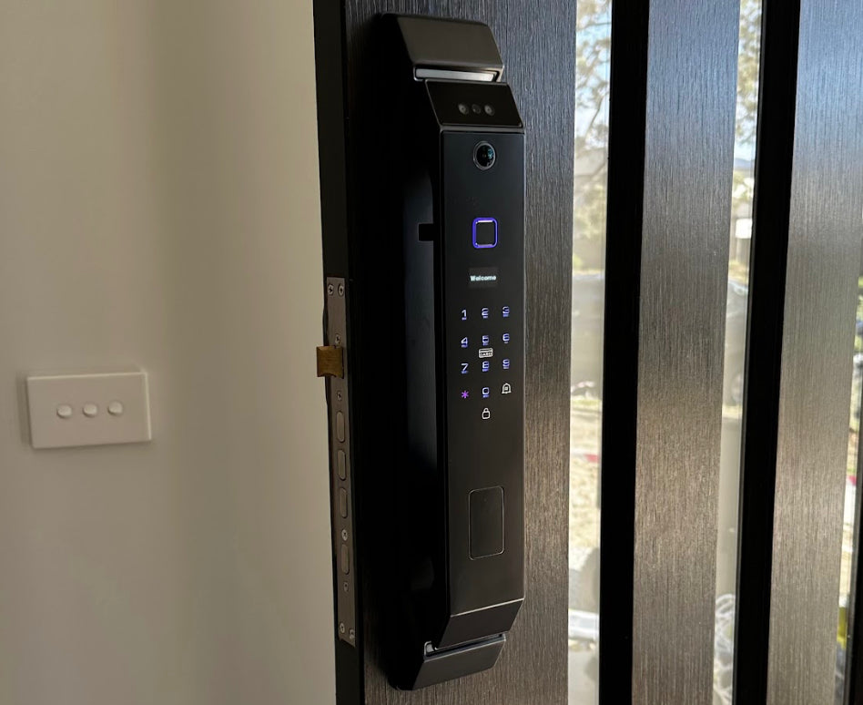 Active black smart lock fitted to a dark entrance door