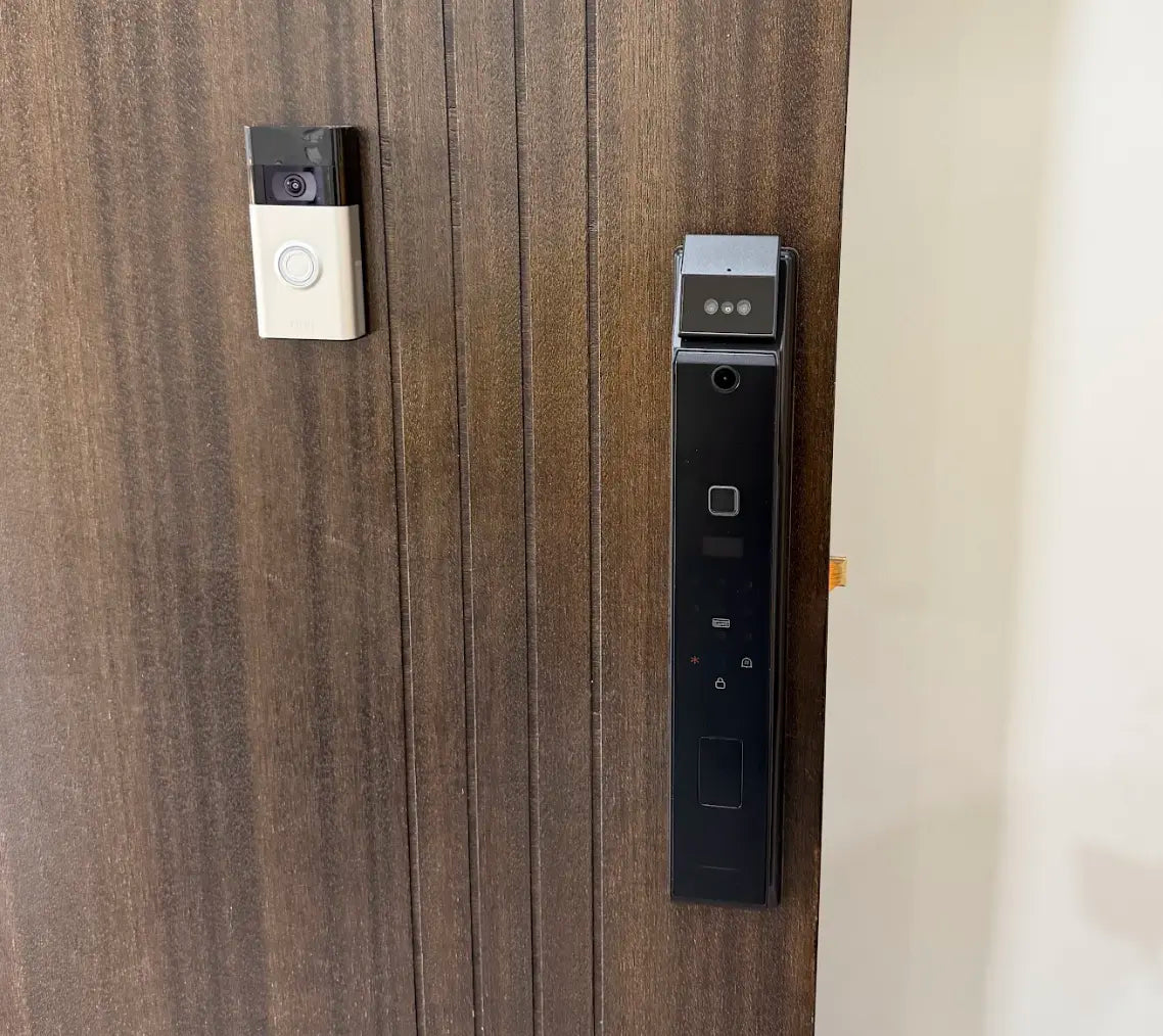 Smart lock and video doorbell on a dark timber door